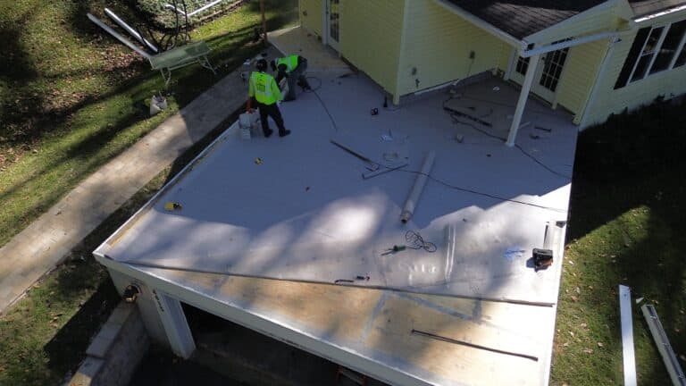 Workers installing roofing on a residential home.