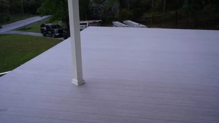 Outdoor deck with wooded surroundings and parked vehicles.