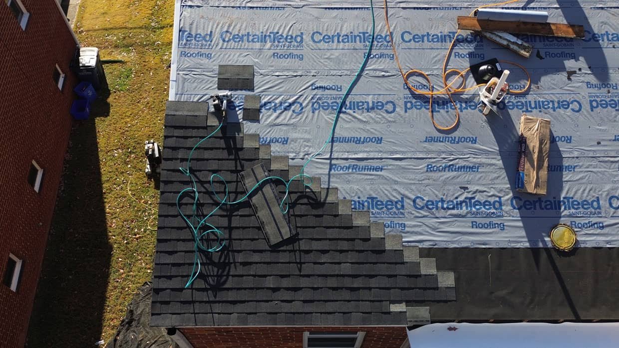 Roof under construction with tools and shingles