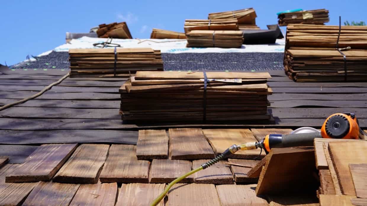 Wooden shingles and tools on a roof under construction.